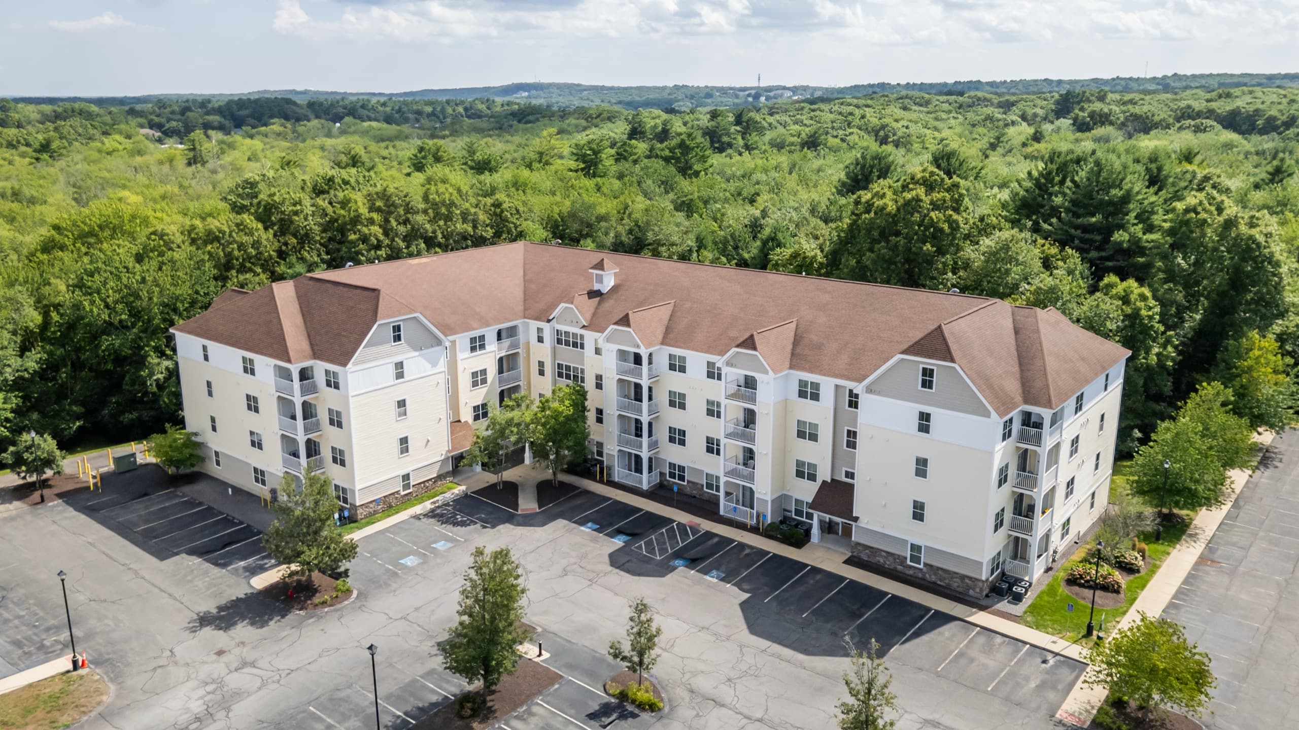 Aerial view of Edgewood Apartments in Plainville, Massachusetts, framed by woodland.